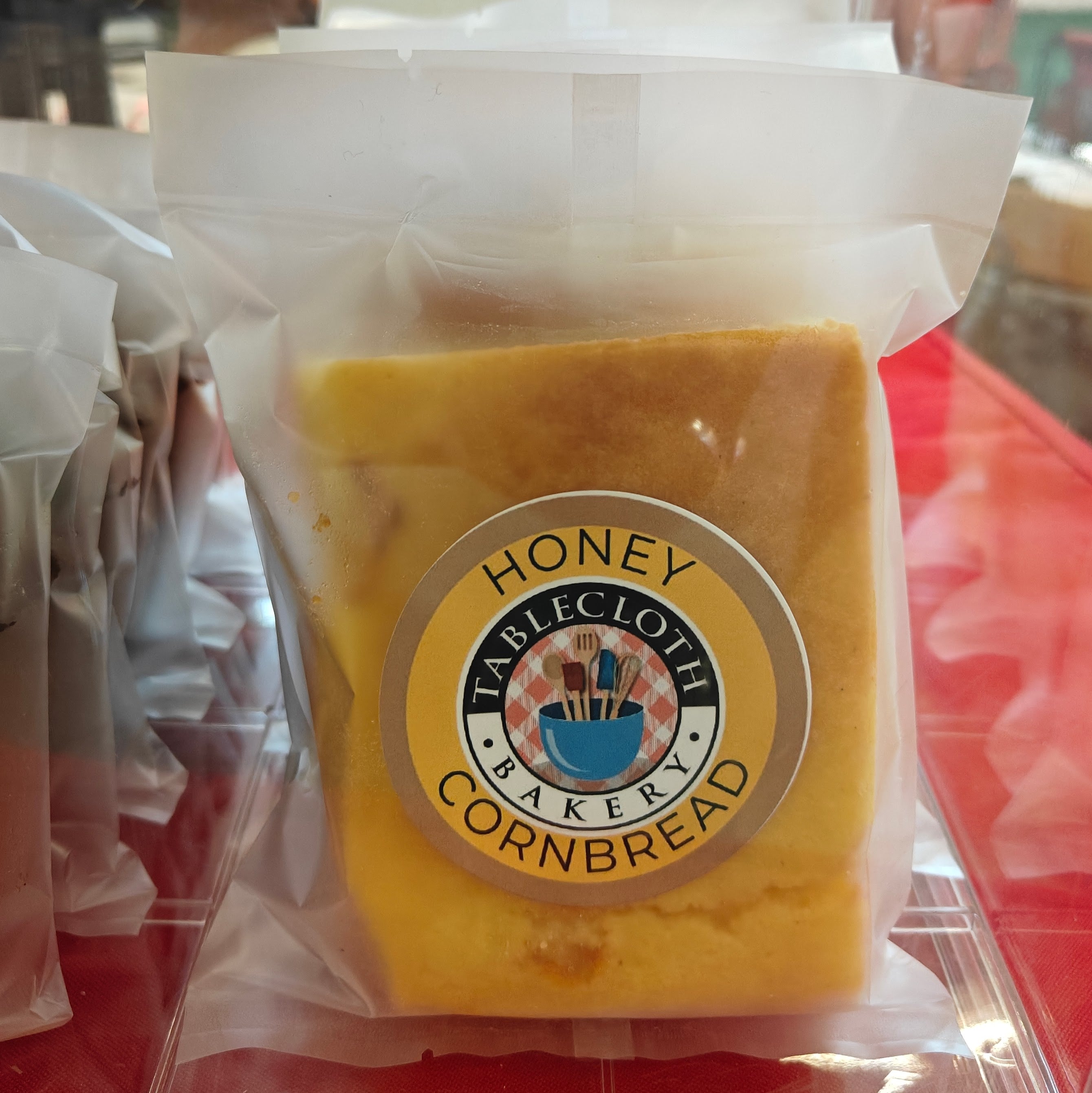 Packaged honey cornbread with a visible label on a red surface